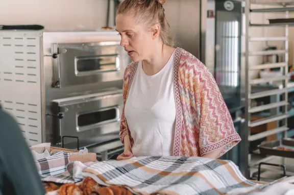 mujer en mostrador de panaderia